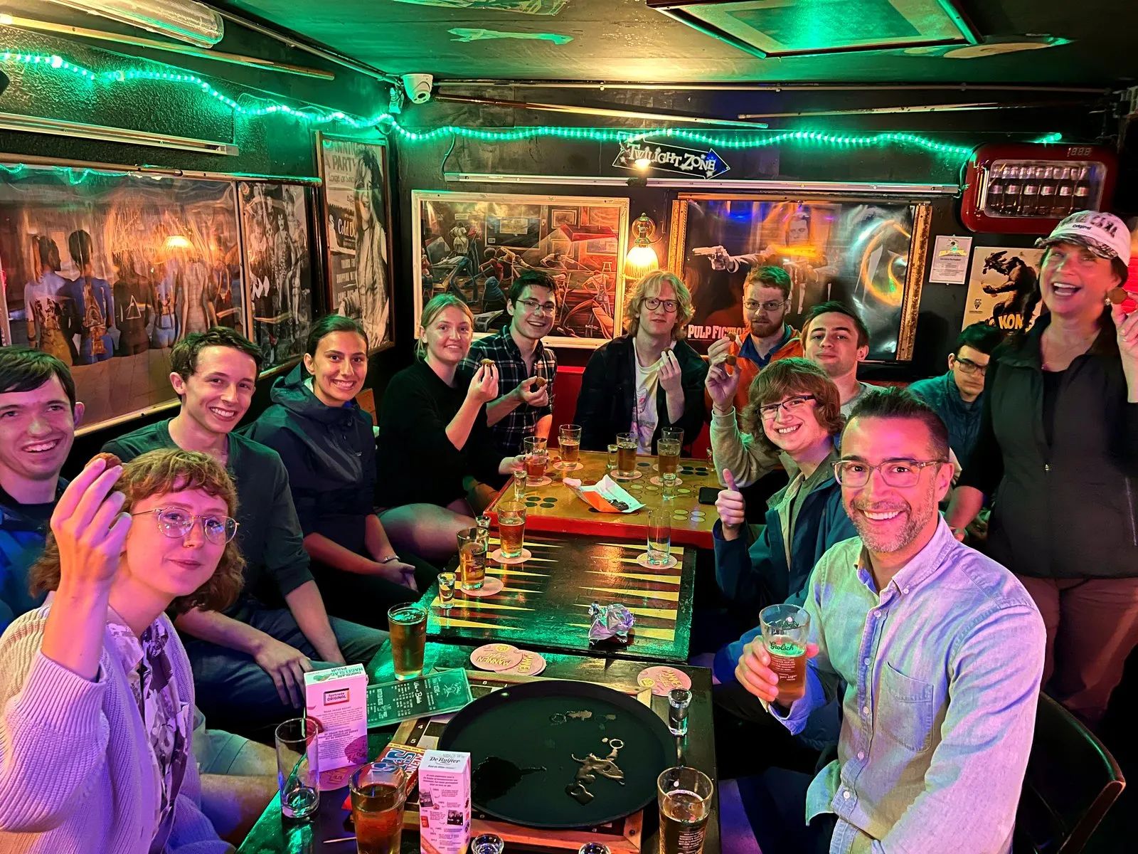 A dozen guests toasting beers around tables on an Amsterdam team outing