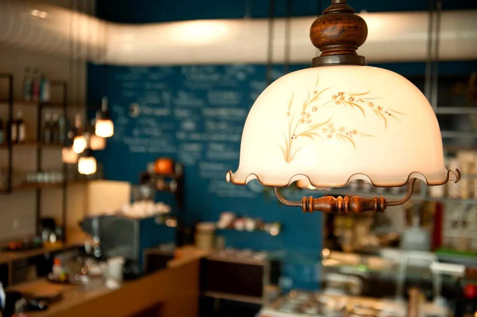 Cosy cafe interior with a vintage glass lamp and chalk menu on a blue wall