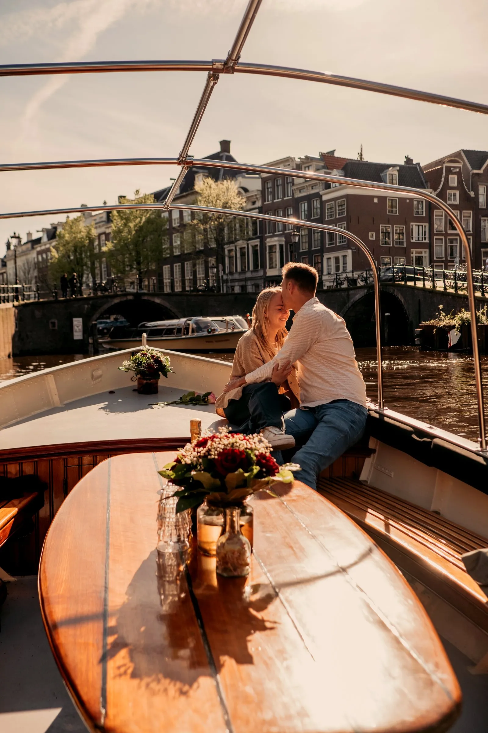 Couple sitting close on a canal boat in golden evening light