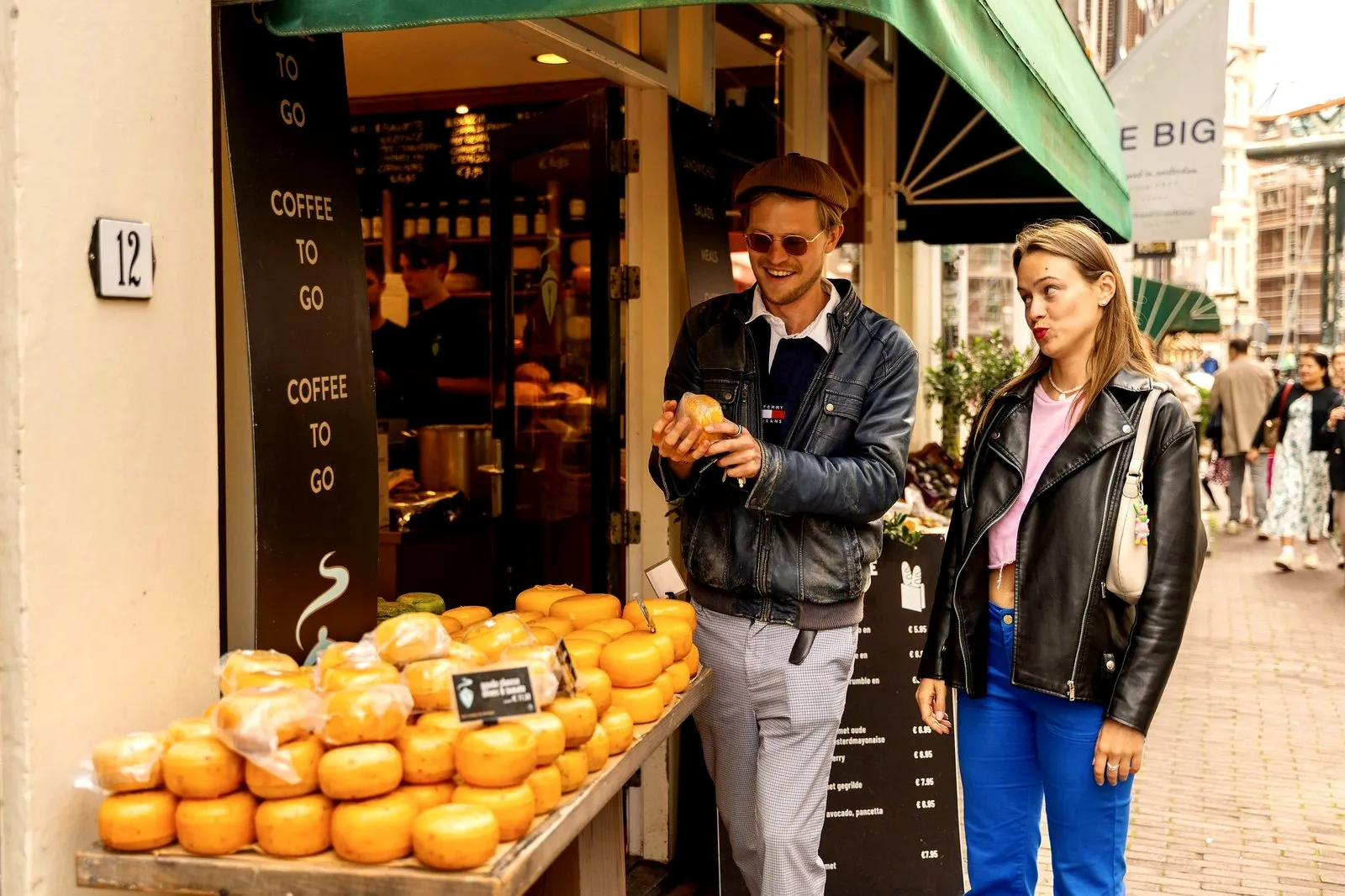 A couple tasting Gouda at an Amsterdam cheese shop
