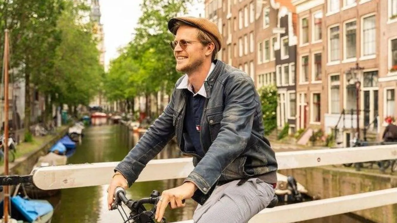 Person enjoying a relaxed bike ride during a guided tour through the streets of Amsterdam.