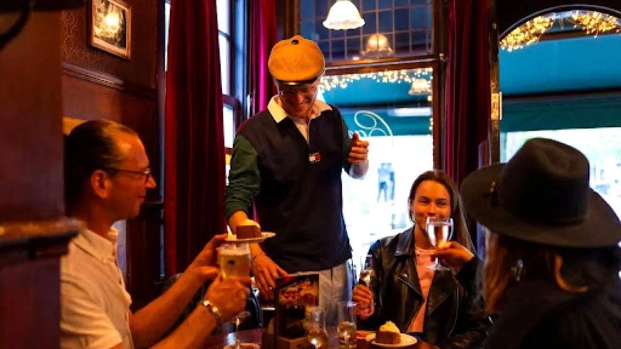 Guests tasting apple pie and drinks with their guide in a classic Amsterdam brown cafe