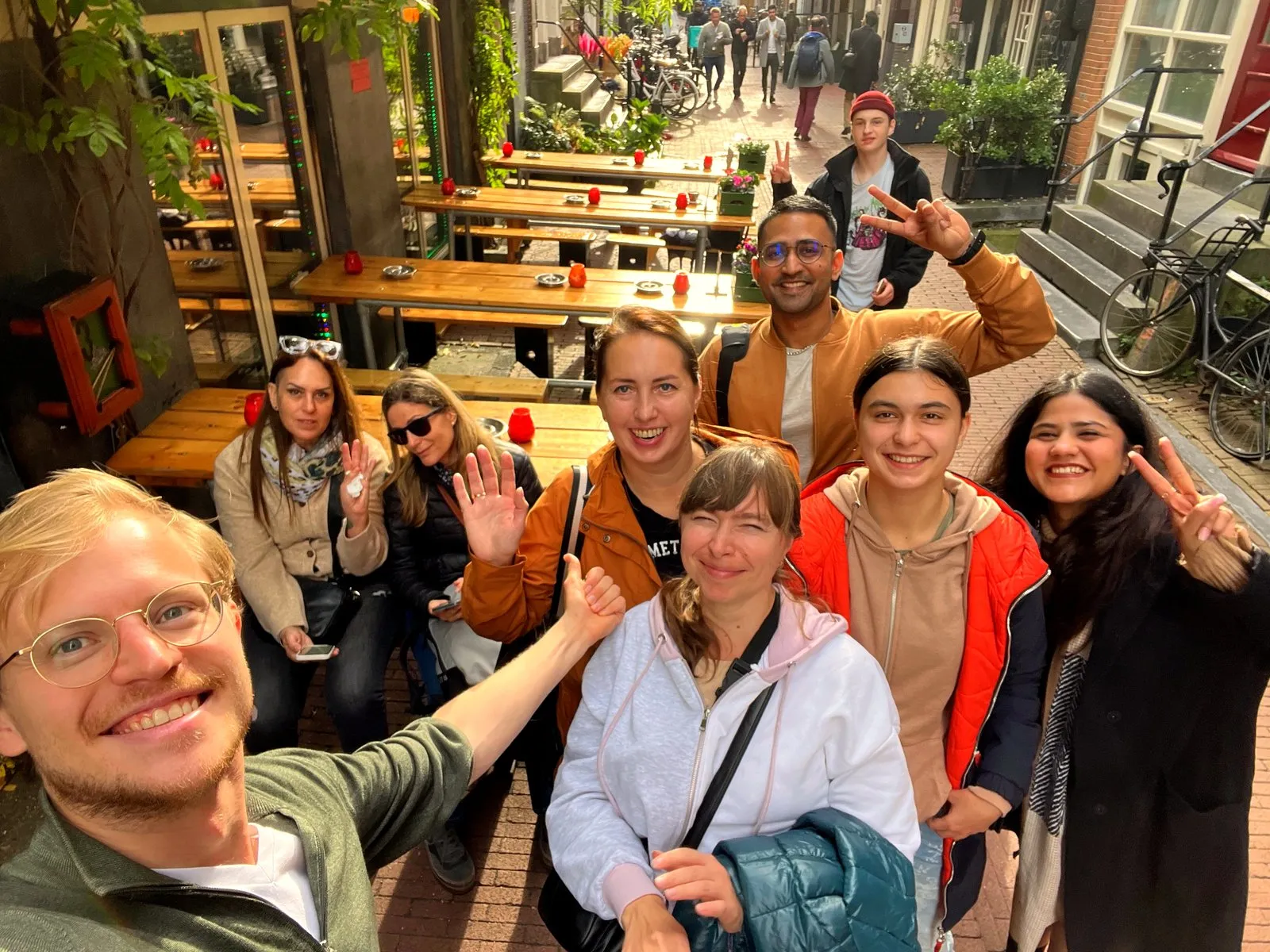A small food tour group taking a selfie in a hidden Amsterdam courtyard