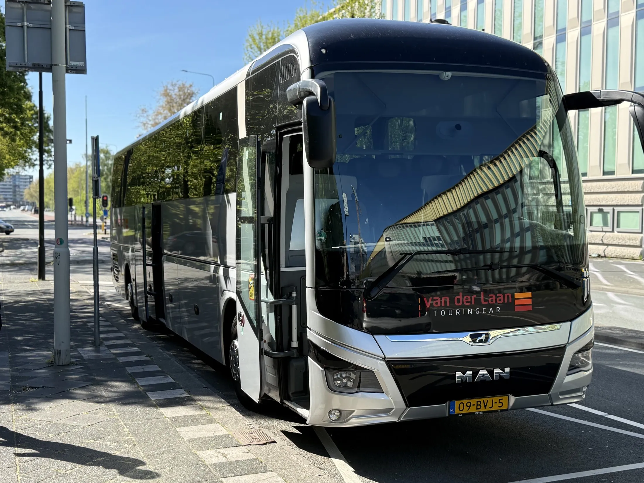Black MAN touring coach parked kerbside in Amsterdam, ready for a group outing