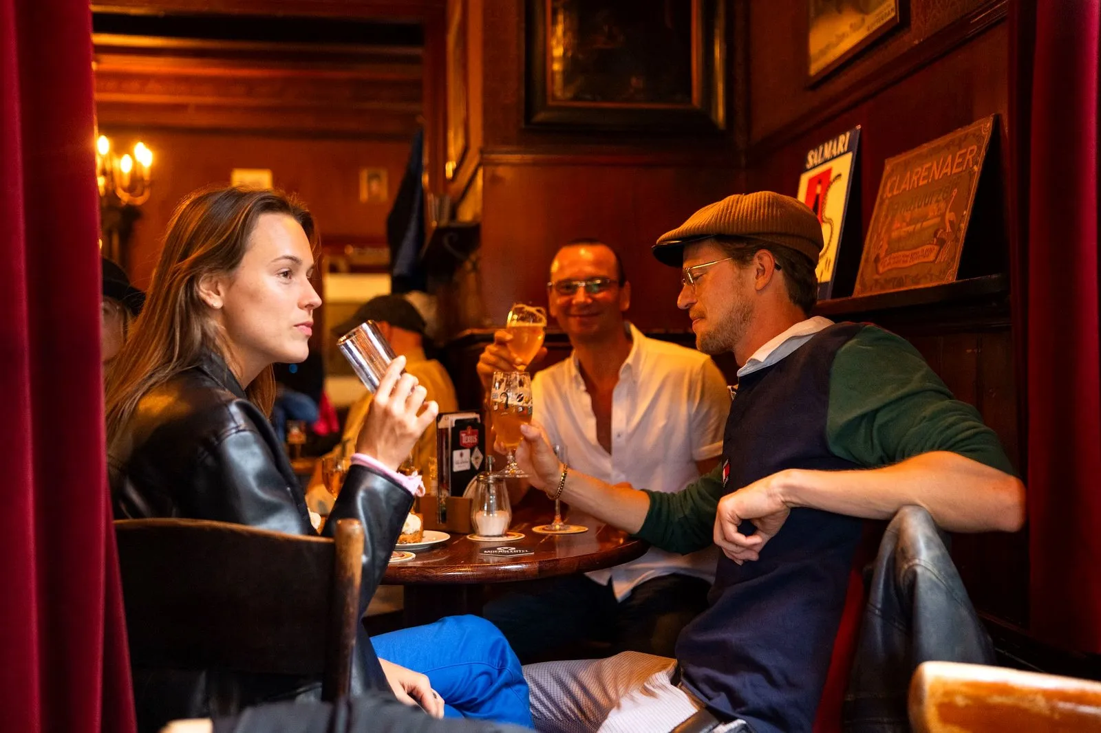 Guests clinking jenever glasses in a sunny Amsterdam tasting room