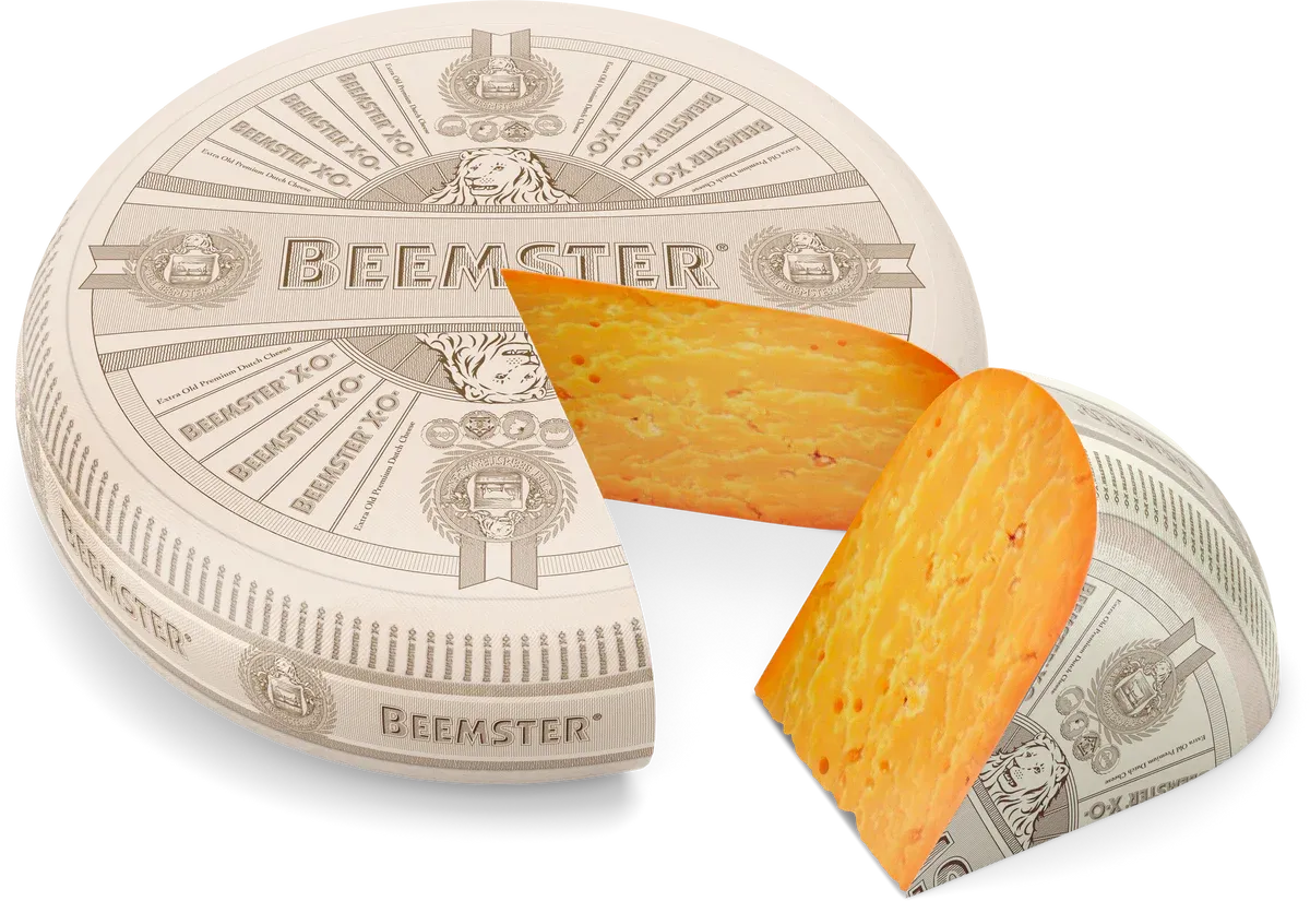 Wheel of Beemster XO aged Dutch cheese with a wedge cut out showing deep orange paste with crystals