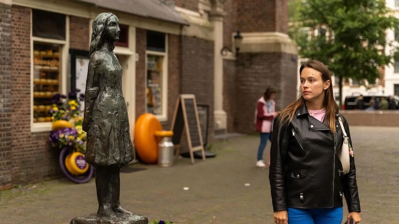 Tour guest walking past the Anne Frank statue in Amsterdam